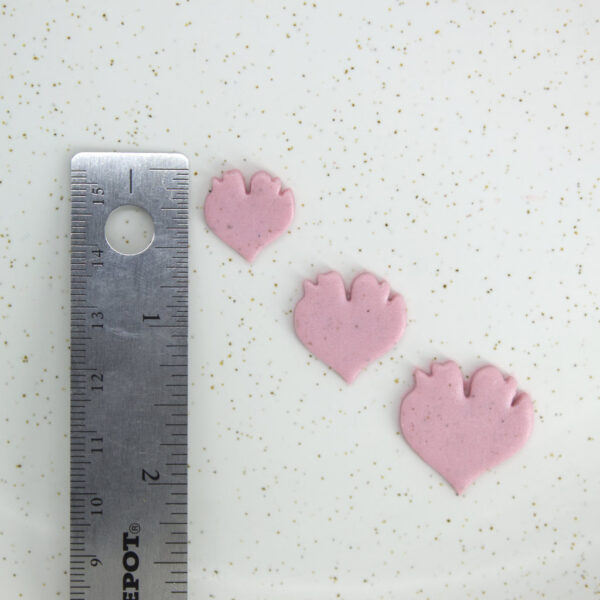 A detailed view of a clay cutter with a distinctive petal shape, a vital tool for crafting handmade polymer clay earrings