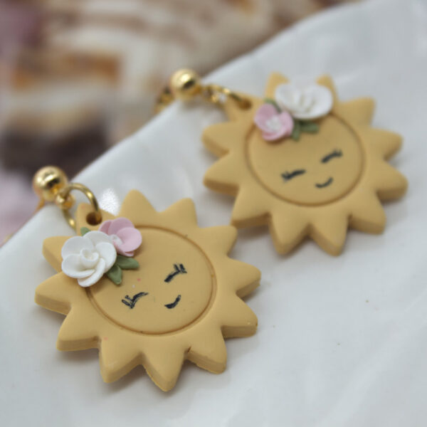 Handmade polymer clay earrings in a unique sun design, perfect for summer style.