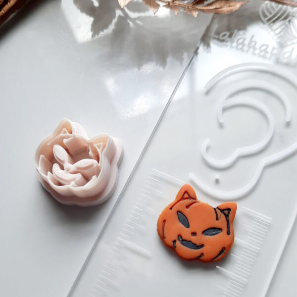 Polymer clay cutters in the shape of a cat nestled in a pumpkin, ready to be used for Halloween or fall-themed earring creations