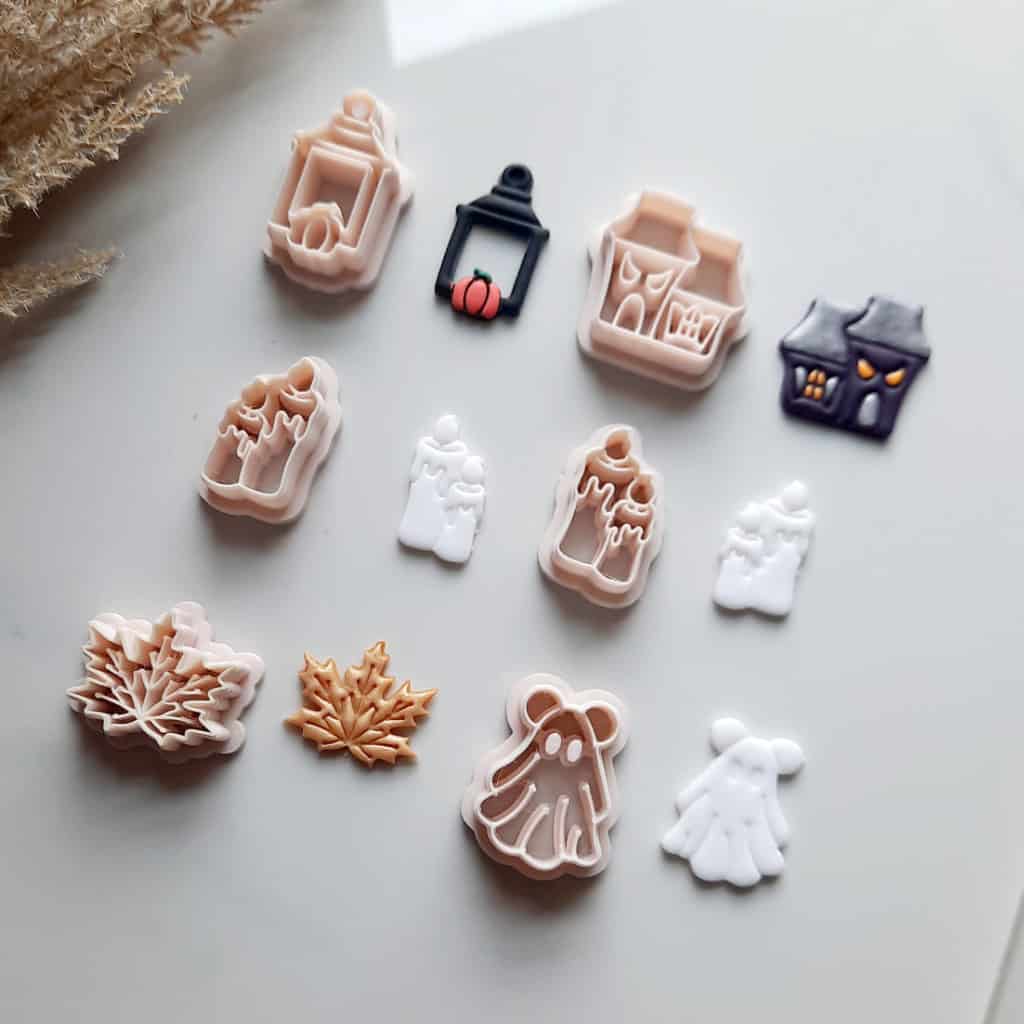 Six themed clay cutters arranged neatly, each with a unique design for Halloween and fall. The collection includes a quaint lantern, a spooky haunted house, a set of flickering candles, an adorable mouse ghost, maple leaf. Fall clay cutters