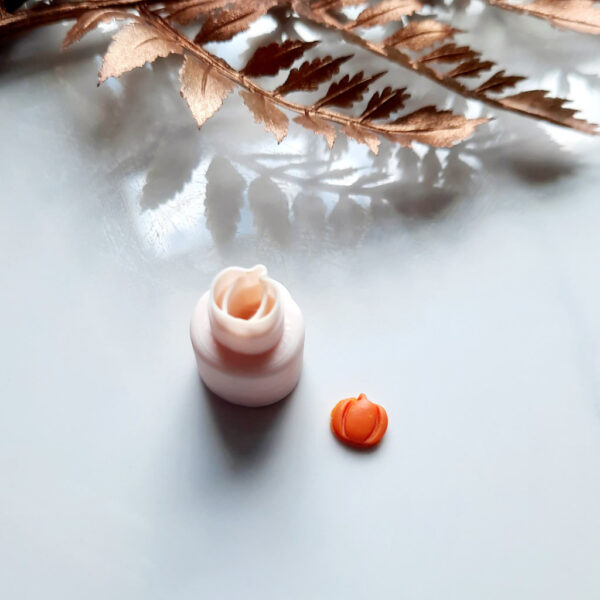 Close-up view of a micro pumpkin clay cutter, a tool used for creating Halloween-themed polymer clay earring