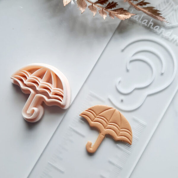 Array of clay cutters including the featured umbrella cutter, used for creating unique polymer clay earring designs