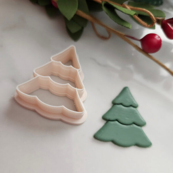 Handheld Christmas tree polymer clay cutter for DIY earring projects.