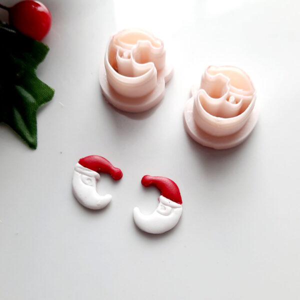 Detailed image of a polymer clay cutter designed as a half-moon wearing a Christmas hat, ideal for creating Christmas themed earrings.