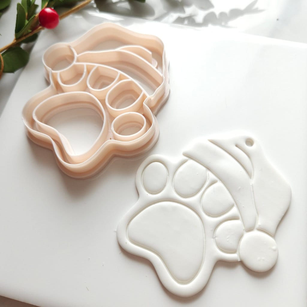 Polymer clay cutter designed to shape Santa Claus dog paw ornaments for a festive Christmas theme